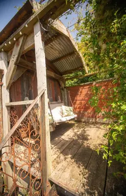 an entrance to a building with a porch with a gate at Little Lodge Glamping in Halesworth