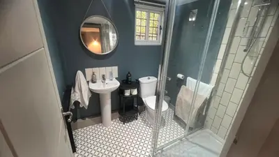 a bathroom with a sink and a toilet and a mirror at Lavender Lodge - Pool and Hot Tub with sunset views over open fields in Wymondham
