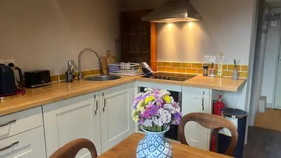 a kitchen with a vase of flowers on a table at Lavender Lodge - Pool and Hot Tub with sunset views over open fields in Wymondham