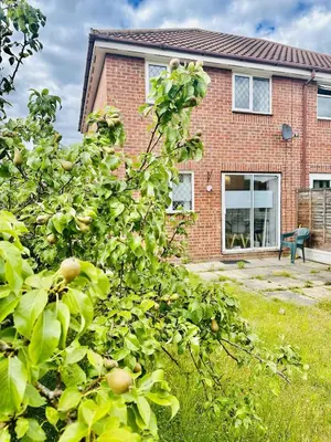 an apple tree in front of a brick house at Kinlett close in Mile End