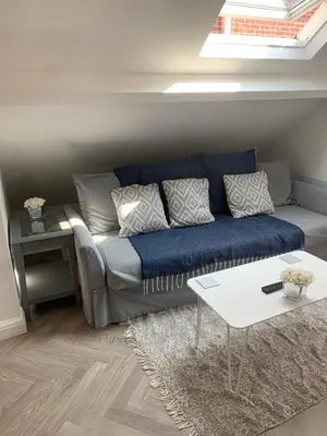 a living room with a couch and a table at Cosy Studio Apartment in Leigh-on-Sea, Close to Bell Wharf Beach & Adventure Island in Leigh-on-Sea