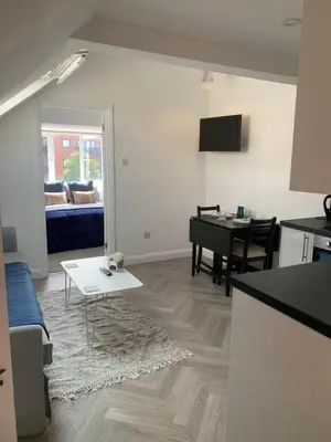 a living room with a couch and a table at Cosy Studio Apartment in Leigh-on-Sea, Close to Bell Wharf Beach & Adventure Island in Leigh-on-Sea