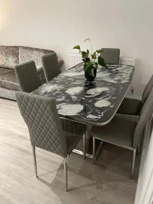 a dining room table with chairs and a vase with a plant at 1 Bedroom Apartment By Brookland Stays Serviced Accommodation Short Lets Essex With Free WIFI in Brentwood