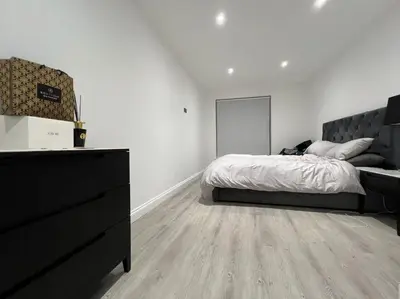 a white bedroom with a bed and a dresser at 1 Bedroom Apartment By Brookland Stays Serviced Accommodation Short Lets Essex With Free WIFI in Brentwood