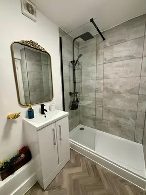a bathroom with a shower and a sink and a mirror at Stylish and Chic Seaside Apartment in Southend-on-Sea