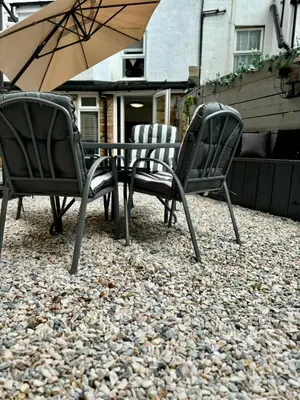 two chairs and a table with an umbrella at Stylish and Chic Seaside Apartment in Southend-on-Sea