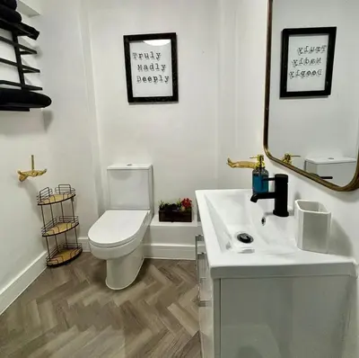 a bathroom with a toilet and a sink and a mirror at Stylish and Chic Seaside Apartment in Southend-on-Sea