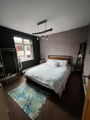 a bedroom with a large bed and a rug at Cozyleigh in Southend-on-Sea