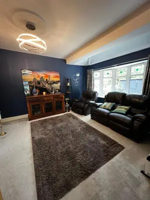 a living room with a leather couch and a rug at Cozyleigh in Southend-on-Sea