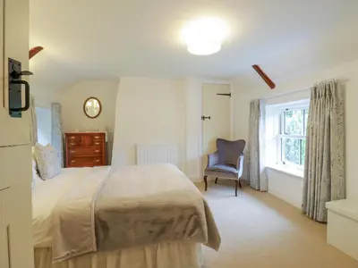 a bedroom with a bed and a chair and a window at West View in Thetford