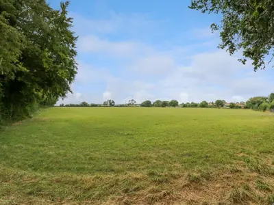 a large open field with trees in the distance at West View in Thetford