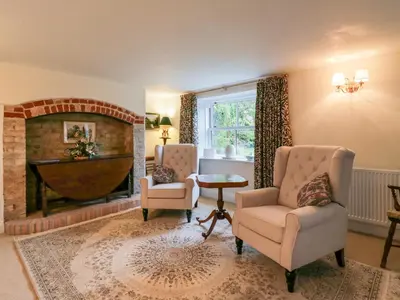 a living room with two chairs and a fireplace at West View in Thetford
