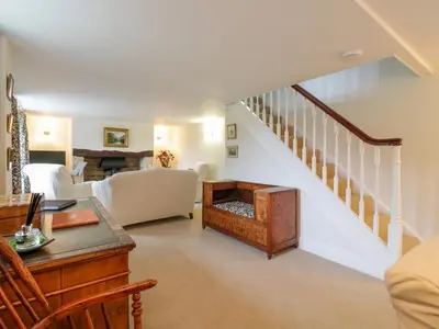 a living room with a staircase with a couch and a table at West View in Thetford