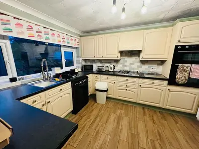a kitchen with white cabinets and black appliances at Contractors families free parking Ramsey Road in St Ives