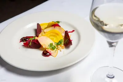 a plate of food on a table with a glass of wine at Swan Hotel & Spa in Lavenham