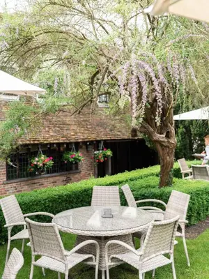 a table and chairs in a yard with a tree at Swan Hotel & Spa in Lavenham