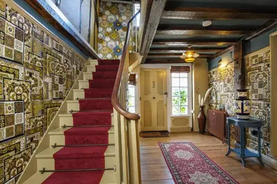 a staircase in a home with a mosaic wall at Luxury 2 Bed Manor House Hot Tub Cinema Room SkyTV in Saffron Walden