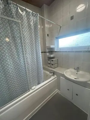 a white bathroom with a sink and a shower at Truehome Close to Stansted Airport in Harlow