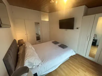 a small bedroom with a bed and a flat screen tv at Truehome Close to Stansted Airport in Harlow