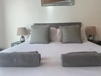 a large white bed with two pillows on it at Truehome Close to Stansted Airport in Harlow