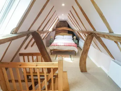 a bedroom with a bed in a attic at Brook Cottage in Saxmundham