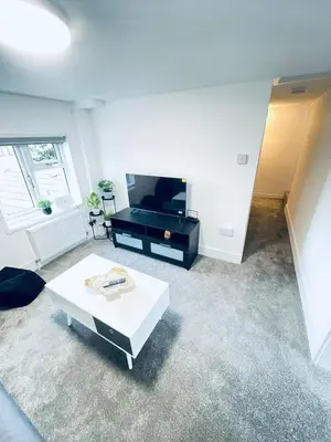 a living room with a white table and a tv at 2 Bed Flat - Sleeps 5 - Parking - Wifi in Cambridge