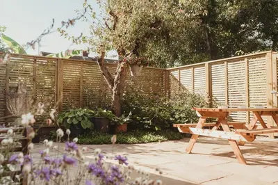 a wooden fence and a picnic table in a garden at 3 Bedroom House with Courtyard Garden and Parking in Chesterton