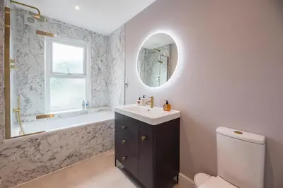 a bathroom with a sink and a tub and a mirror at Rosebank, a stunning holiday home in Aldeburgh in Aldeburgh