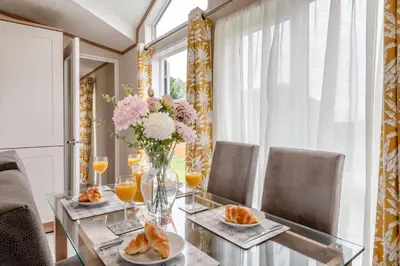 a dining room with a glass table with a vase of flowers at 2 Bed in Welney oc-s29764 in Welney