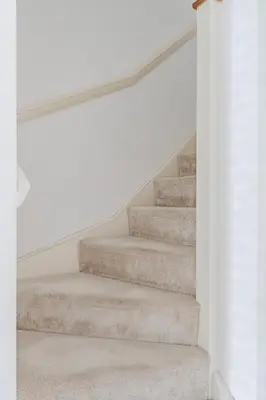 a set of stairs in a house with white walls at Stylish & Chic 3 bed House in Cambourne