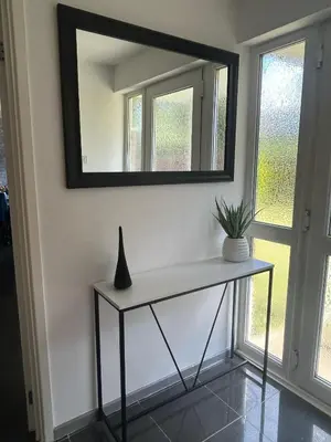 a mirror on a wall with a vase on a table at Luxurious 3 Bedroom Contractor House Stevenage by Randz Property Group - Short Lets l Sleeps 6 l Free Parking & Wifi in Stevenage