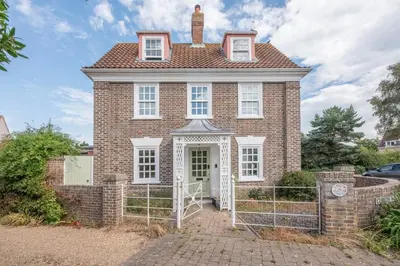 a brick house with a gate in front of it at The Poppies, a stylish Aldeburgh holiday home in Aldeburgh