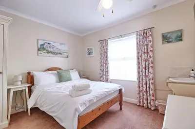 a bedroom with a bed and a window and a sink at Walton Beach Holiday Lets in Walton-on-the-Naze
