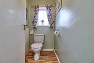 a bathroom with a toilet and a window at Walton Beach Holiday Lets in Walton-on-the-Naze