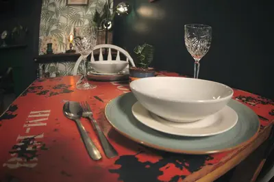 a table with a bowl and plates and wine glasses at Stylish and artistic flat in Southend on Sea - 2 Double Bedrooms, Free on-street parking in Southend-on-Sea