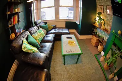 a living room with a leather couch and a coffee table at Stylish and artistic flat in Southend on Sea - 2 Double Bedrooms, Free on-street parking in Southend-on-Sea