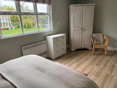 a bedroom with a bed and a dresser and a window at Little Pear Tree in Stock