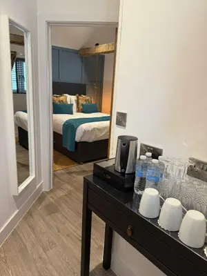 a room with a mirror and a table with water bottles at The Stables Kersey Mill in Whatfield
