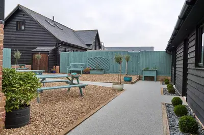 a backyard with a picnic table and a fence at The Stables Kersey Mill in Whatfield