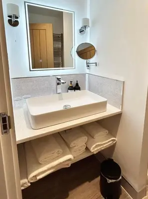 a bathroom with a white sink and a mirror at The Stables Kersey Mill in Whatfield