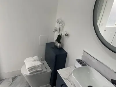 a bathroom with a toilet and a sink and a mirror at Modern-luxury 1bedroom-EnsuiteBathroom-Garden-Wifi in Basildon
