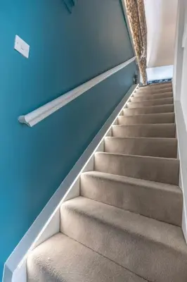a staircase in a room with blue walls at Central Medieval Grid Unique home with Gated parking in Bury Saint Edmunds