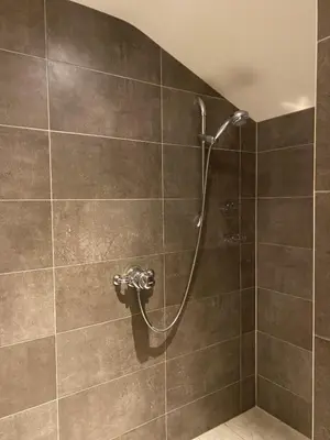 a shower with a hose in a bathroom at Red lion little barn in Ipswich