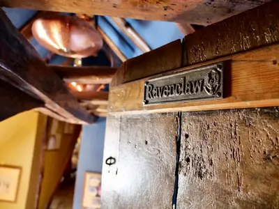 a sign on the side of a wooden door at The Famous Harry Potter House in Saffron Walden