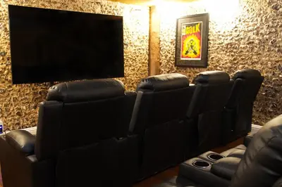 a cinema room with leather chairs and a flat screen tv at The Famous Harry Potter House in Saffron Walden