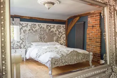 a bedroom with a bed and a brick wall at The Famous Harry Potter House in Saffron Walden