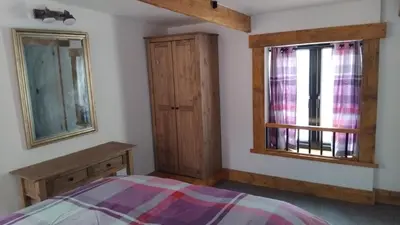 a bedroom with a bed and two windows at St Edmunds Brewery in Downham Market