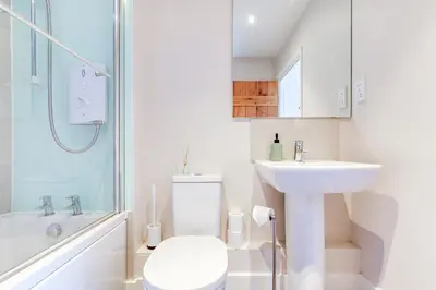 a bathroom with a toilet and a sink and a shower at Harestreet Farm Barns, The Dairy, Parlour and Creamery in Cottered