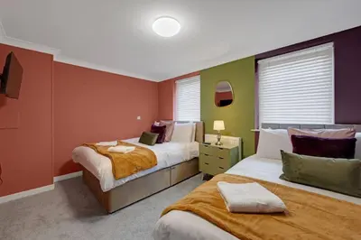 two beds in a room with red and green walls at Harland Haven Spacious 4br House In Ipswich in Ipswich