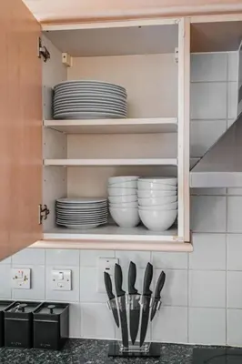 a kitchen cabinet with plates and utensils in it at Harland Haven Spacious 4br House In Ipswich in Ipswich